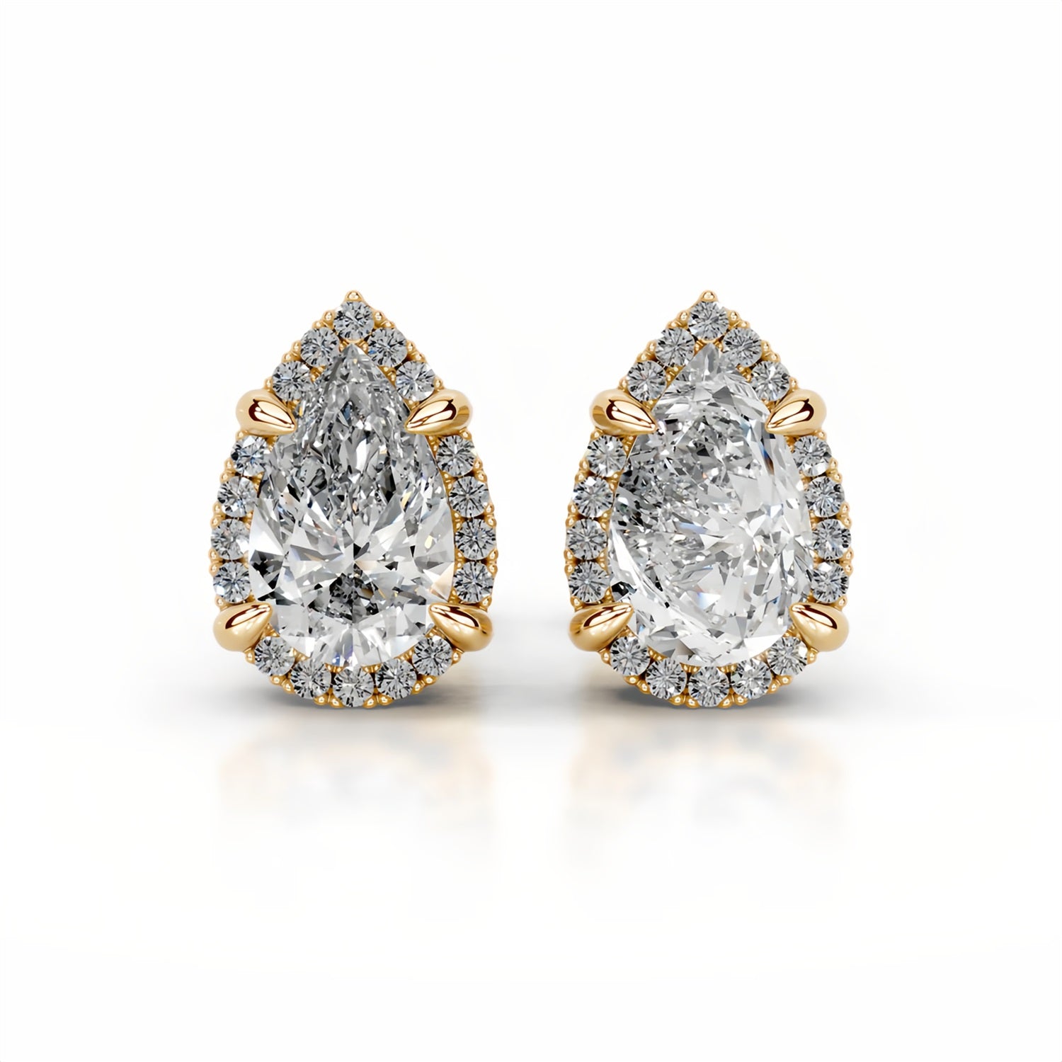 Pair of pear-shaped diamond earrings with gold accents on a white background