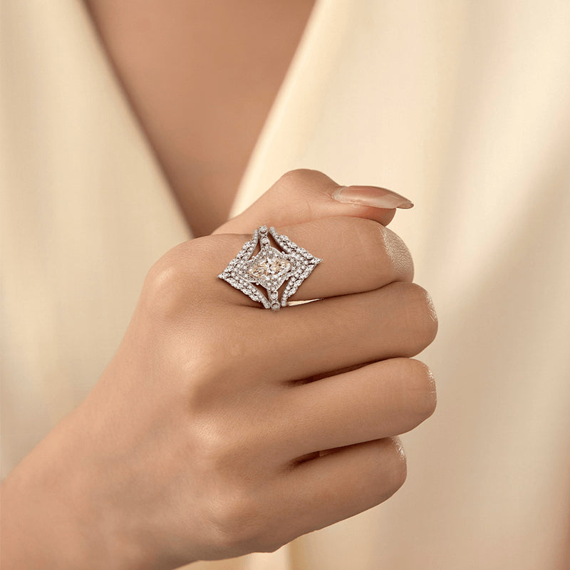 Hand wearing a diamond ring on a beige background