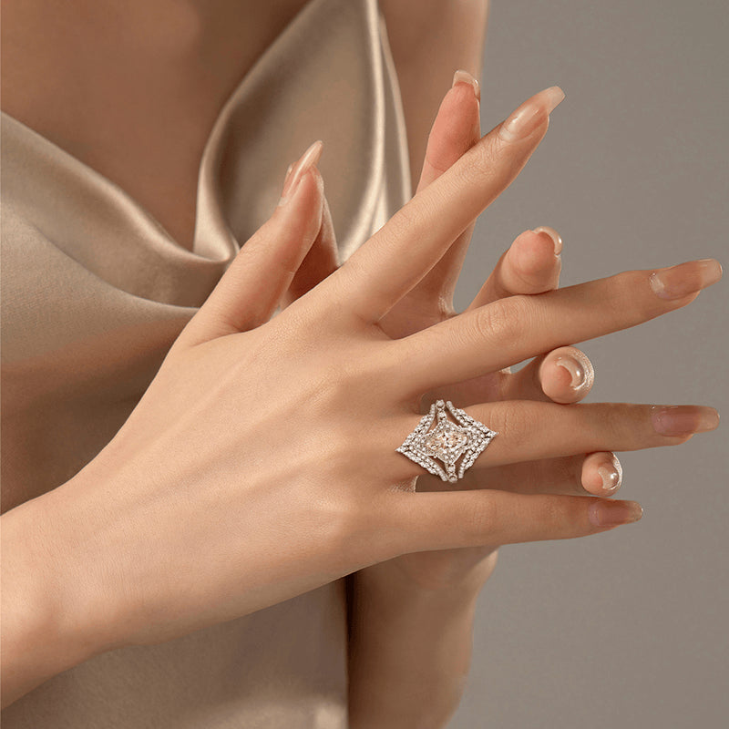Hand wearing a diamond ring with a neutral background